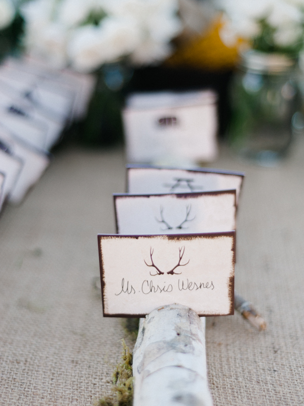 Moss, a branch and some cards with antlers look cool and woodland like and bring that cozy feel to your wedding