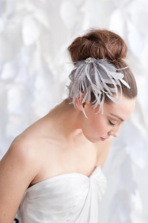 a top knot with a whimsical and chic feather and rhinestone headpiece is a gorgeous solution for a modern refined bridal look