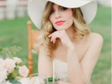 a bride wearing a pretty neutral hat for a more modern and refined look and to protect your hair and head from excessive sunshine
