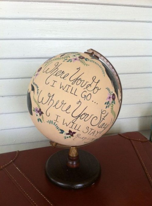 a vintage globe with black calligraphy that is a romantic quote is a cool DIY decoration for a wedding, it looks cute and chic