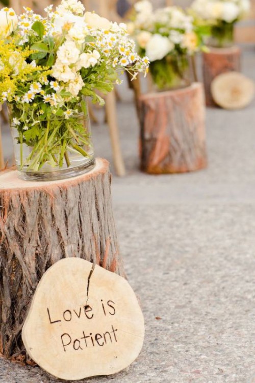 tree stumps with greenery and blooms and tree slices with quotes is a lovely idea for a rustic or woodland wedding