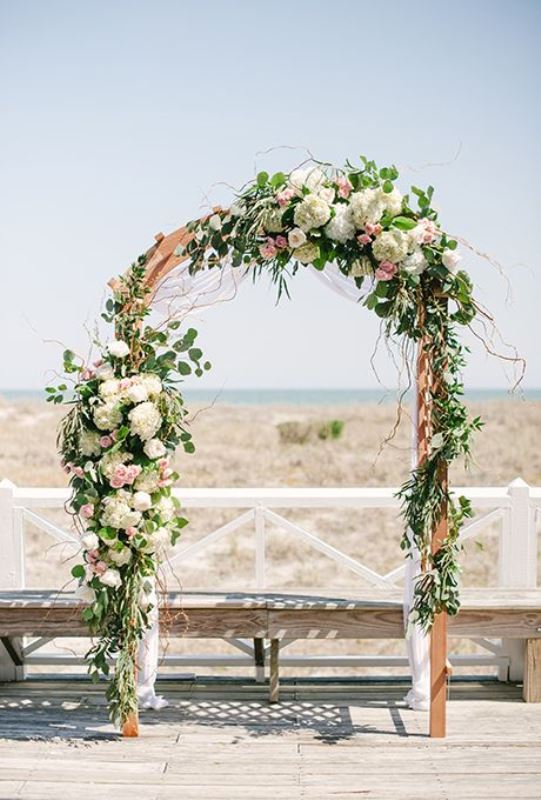 A lovely wedding arch with blush, white blooms, eucalyptus and twigs is a pretty and very romantic idea