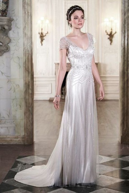 a fitting embellished wedding dress with short sleeves, a deep neckline and a train