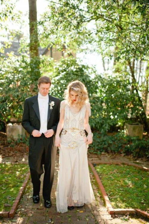 a neutral 1920s inspired wedding dress with gold embellishments, a V-neckline and cap sleeves