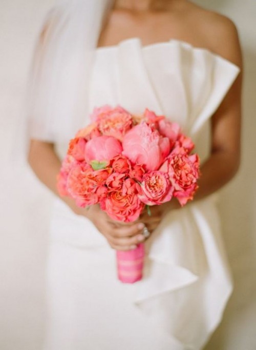 a coral and pink wedding bouquet is a bold and catchy idea for a spring or summer wedding