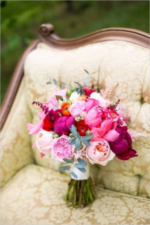 a pink wedding bouquet with fuchsia, hot pink, blush and orange blooms, some greenery is a cool idea for a bright wedding