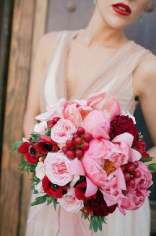 a burgundy and pink wedding bouquet with peonies, anemones, roses and berries for a red and pink wedding