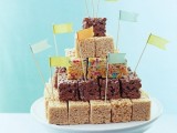 a wedding cake composed of various pieces of krispy rice with colorful toppers looks fun and costs cheap