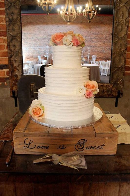 A pallet cake stand with handwriting is a stylish idea for a rustic wedding