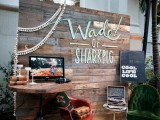 a backdrop for a photo booth or another space made of pallets with tassel garlands and letters on it
