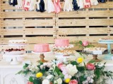 a pallet backdrop with colroful letters and tassel garlands can be used anywhere throughout your wedding venue