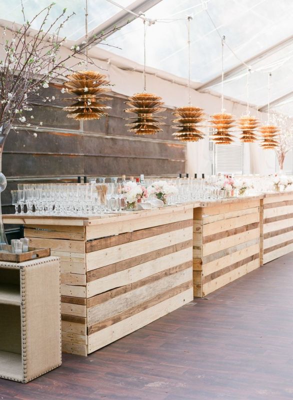 A large wedding drink station fully built of pallet wood is a cool recycling idea for a rustic wedding