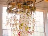 a pallet with flower garlands hanging down and some succulents and moss on top is a simple and cute alternative to an overhead installation