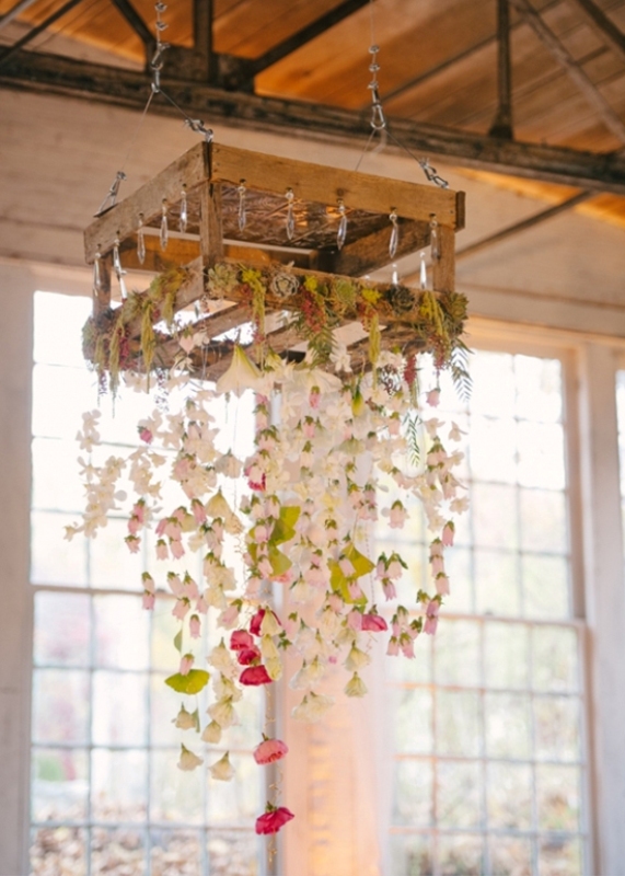 A pallet with flower garlands hanging down and some succulents and moss on top is a simple and cute alternative to an overhead installation