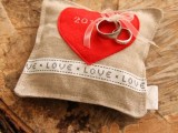 a burlap pillow with a heart applique on top is a pretty pillow idea for a rustic wedding