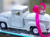 a vintage toy pickup with rings attached with a bright pink ribbon box is a fun idea for a retro-infused wedding