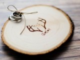 a burnt wood slice with antlers and twine is a cool idea for a rustic or woodland wedding