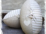 an oval striped and heart printed pillow with wedding rings attached is a fun and creative idea