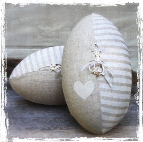 an oval striped and heart printed pillow with wedding rings attached is a fun and creative idea