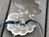 a metal seashell with a blue ribbon is a cool idea for a coastal or a beach wedding