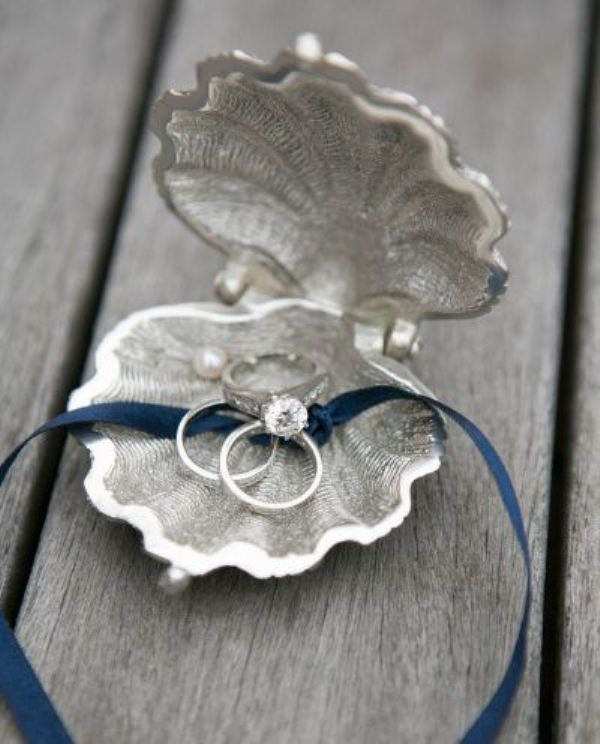 A metal seashell with a blue ribbon is a cool idea for a coastal or a beach wedding