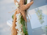 accent wedding chairs with white orchids, greenery and a starfish to make them look tropical and beach-like