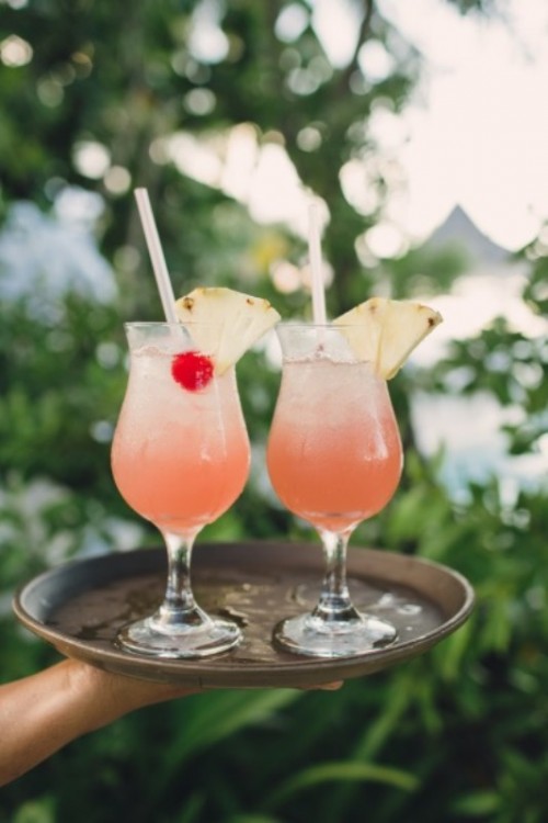 ombre pink refreshing cocktails with cherries and pineapples are lovely for making your beach wedding guests refreshed and happy