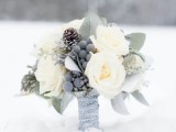 a neutral wedding bouquet with berries, pinecones, white blooms and leaves is a stylish and beautiful idea to rock