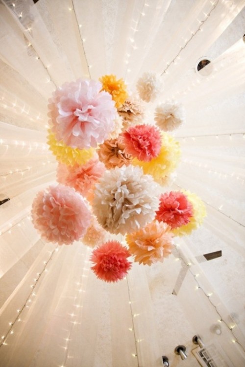 a colorful paper pompom chandelier is a budget-friendly alternative to a usual floral one, and it looks very party-like