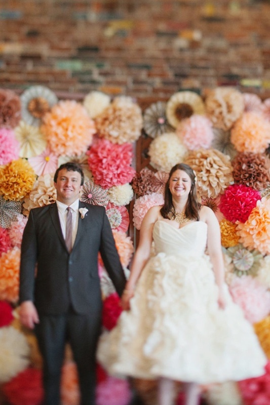 a super colorful wedding backdrop composed of bright paper pompoms and balls is a lovely idea for a modern party inspired wedding