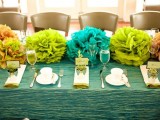 bright paper pompoms used instead of bright floral centerpieces are a great and very budget-friendly idea