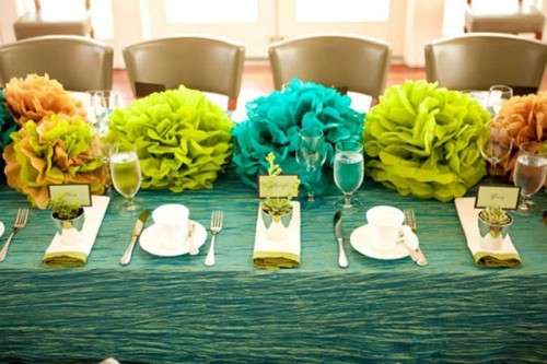 bright paper pompoms used instead of bright floral centerpieces are a great and very budget-friendly idea
