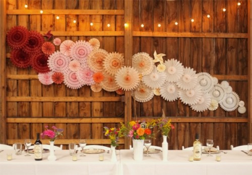 a pretty and cool ombre wedding backdrop made of paper fans is a lovely idea for a wedding, it works for the ceremony, reception and not only
