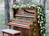 a beautiful piano decorated with lush greenery and blush blooms can be used to gift a song to each other, for the ceremony and to take pics