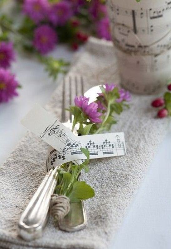 Wedding cutlery with blooms secured with note paper is a nice idea for a music loving wedding