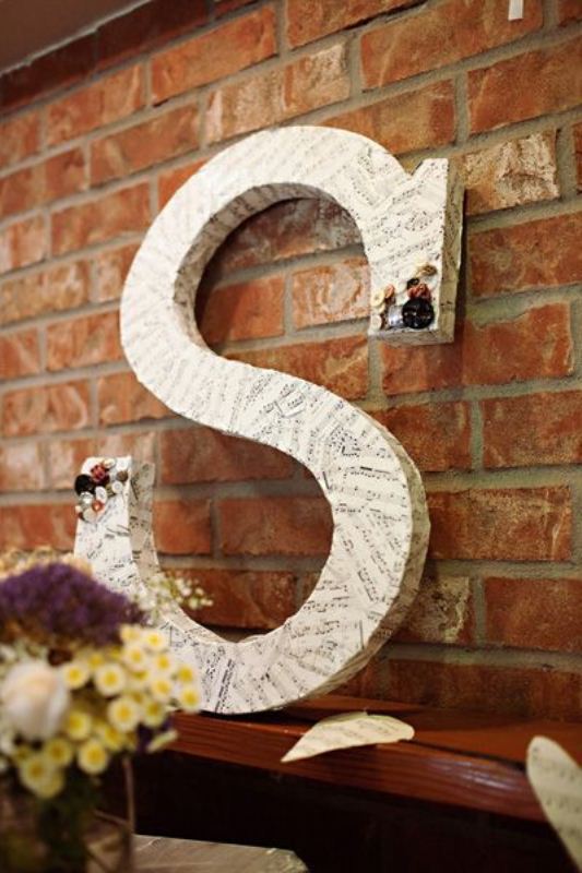 An oversized letter wrapped with note paper is a cool decoration for the venue and can be DIYed by you yourself