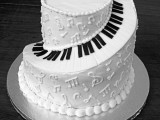 a black and white wedding cake showing off piano key buttons and notes on its sides