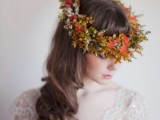 a bold and creative fall floral crown with various types of colorful greenery and orange blooms is a unique idea