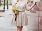 a neutral knee wedding dress with a lace bodice with short sleeves and a pleated shiny skirt, neutral flats and a side braid for a city hall wedding