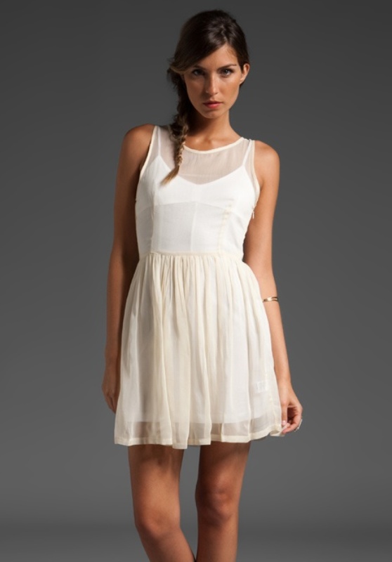 A modern white mini dress with no sleeves and an illusion neckline, with a pleated skirt is ideal for a city hall elopement
