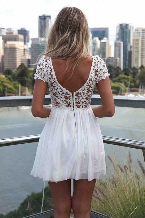 a white mini dress with a floral bodice with a cutout back and short sleeves and a pleated skirt