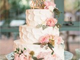 a white textural buttercream wedding cake with blush blooms and greenery, a calligraphy topper is a great spring or summer garden wedding dessert