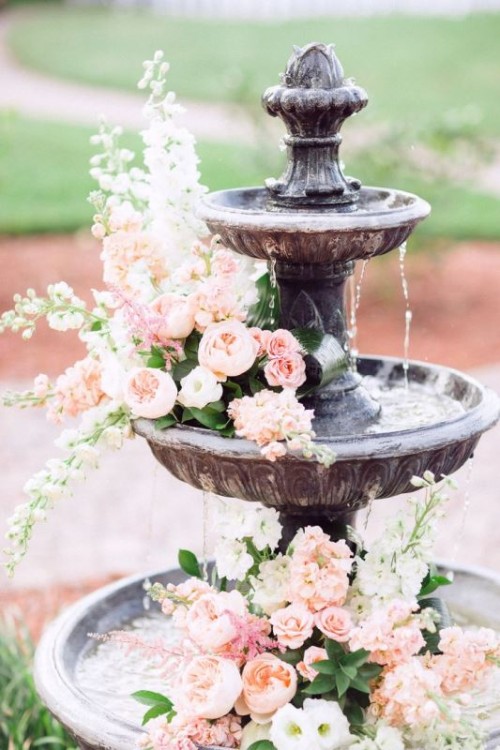 a vintage fountain with pink blooms on each tier is a lovely idea for a garden wedding, it's beautiful and chic