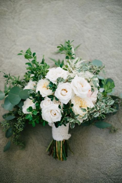 a lush wedding bouquet with greenery and white blooms is a lovely idea for a spring or summer wedding in a garden