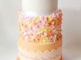 a bright wedding cake with several tiers, with sugar blooms attached to one tier and funny and cute love bird cake toppers
