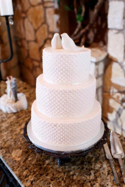 a white polka dot wedding cake with love birds topping it is a cool and stylish idea for any wedding, such toppers aren't seen every time