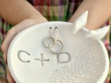 a white clay plate with doily pattern and two little love birds attached to the edge is a cool alternative to a ring pillow