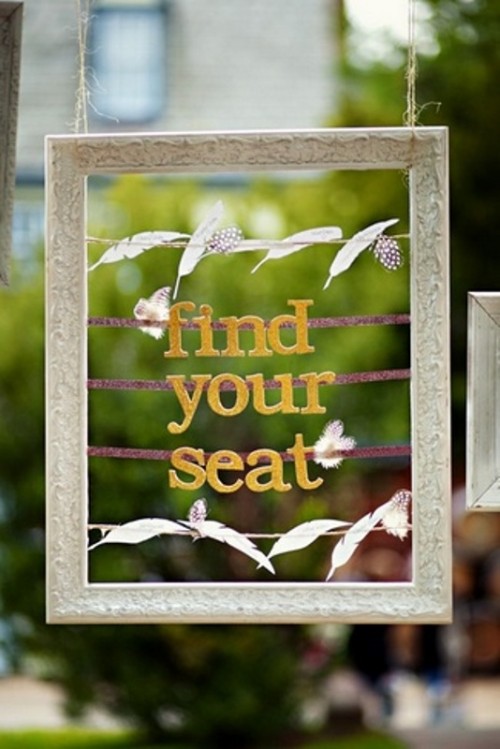 an ornated frame with feathers as a sign to find a seat is a cool and cute idea for a rustic wedding, make one yourself