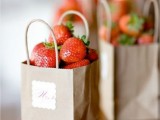 fresh strawberry in paper bags is a great summer wedding or rehearsal dinner favor idea