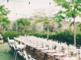 an uncovered table with greenery, lemons and candles for a chic yet relaxed Tuscany wedding